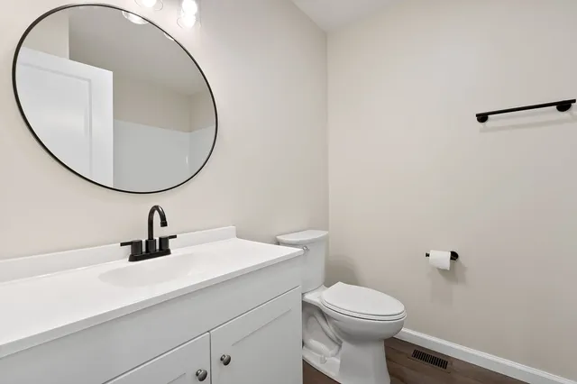 a bathroom with a sink a toilet and a mirror