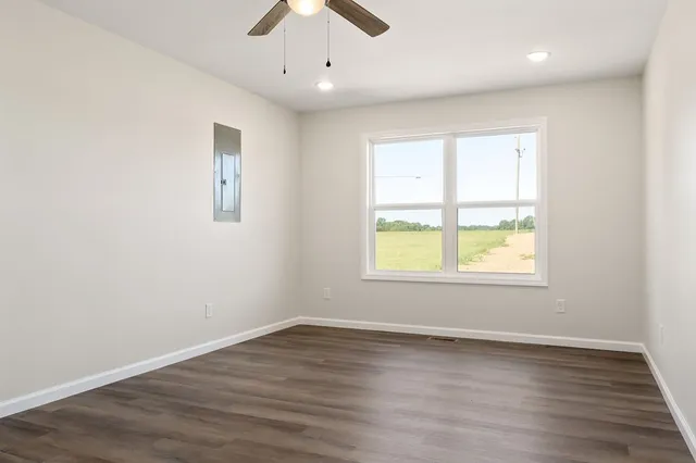 an empty room with wooden floor and windows