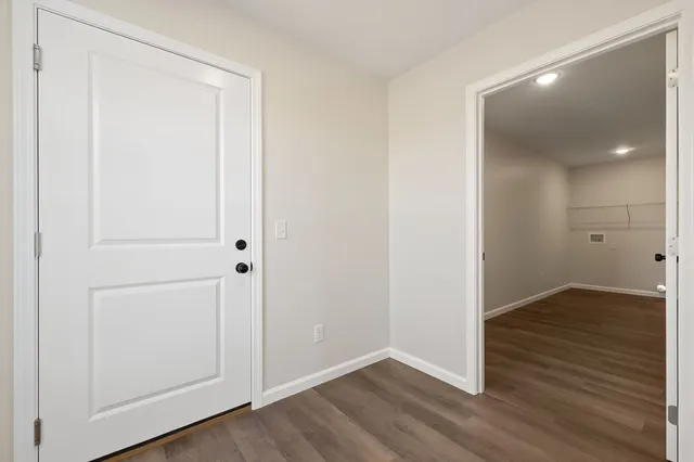 an empty room with wooden floor & closet