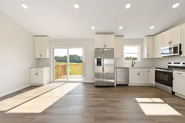 a kitchen with kitchen island a counter top space a refrigerator and cabinets