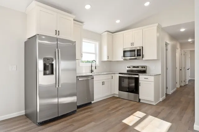 a kitchen with kitchen island a counter top space a refrigerator and cabinets