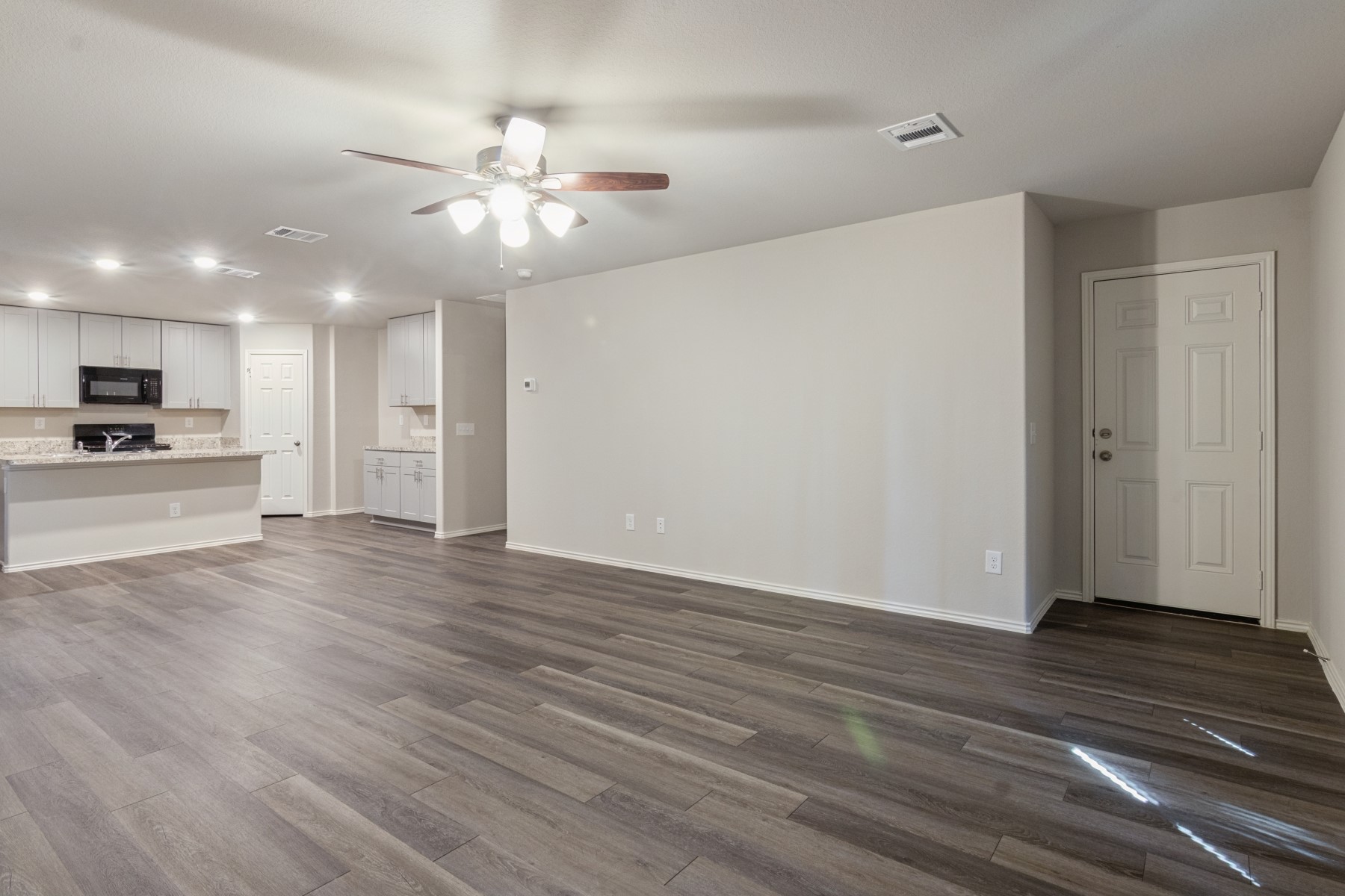 2250 Yelverton Ter Trail Spring, TX 77373 - Photo 9 of 30 a view of an empty room with wooden floor and a ceiling fan