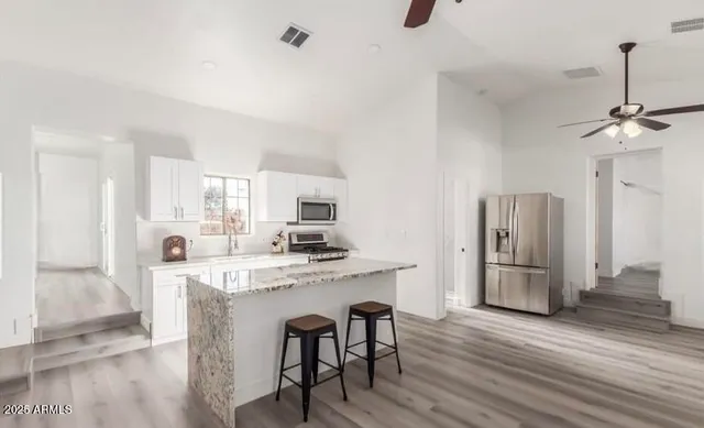 a kitchen with refrigerator cabinets and wooden floor