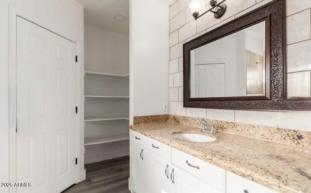 a bathroom with a granite countertop sink and a mirror