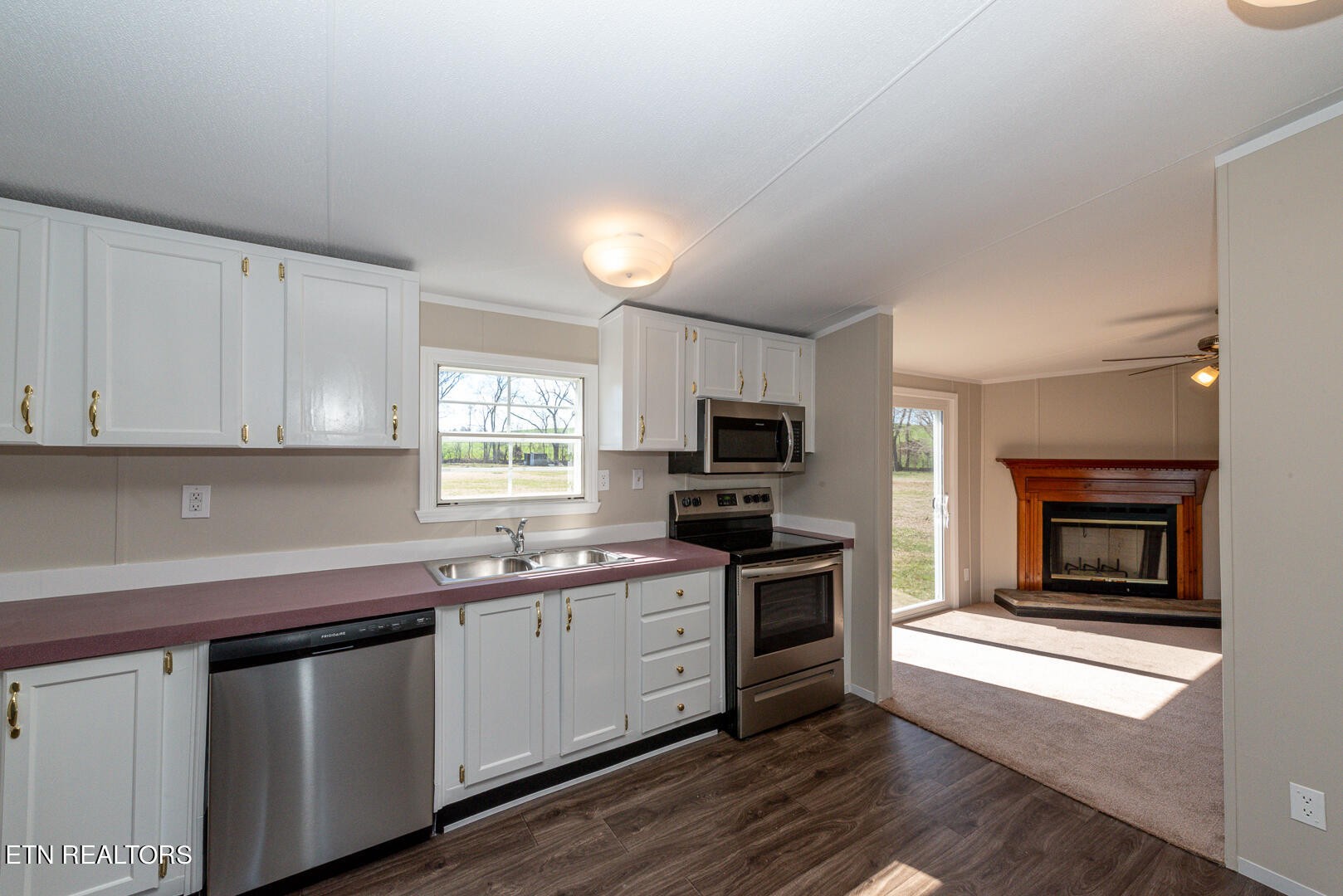 1602 Fork Creek Road Philadelphia, TN 37846 - Photo 7 of 26 a kitchen with stainless steel appliances granite countertop a sink dishwasher a stove and a microwave oven with cabinets