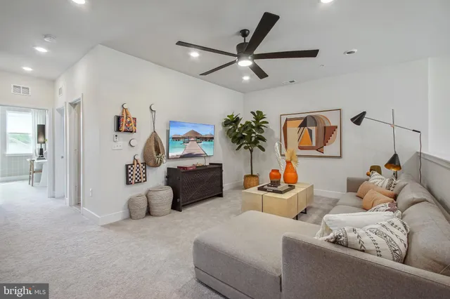 a living room with furniture and a ceiling fan