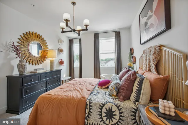 a bedroom with a bed and dresser with mirror