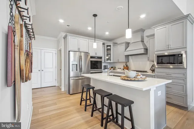 a kitchen with stainless steel appliances a stove a sink island and a refrigerator