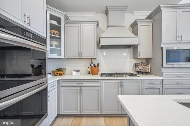 a kitchen with stainless steel appliances a stove a sink and cabinets