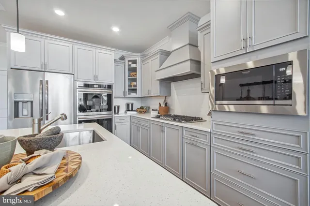 a kitchen with stainless steel appliances a stove microwave and sink