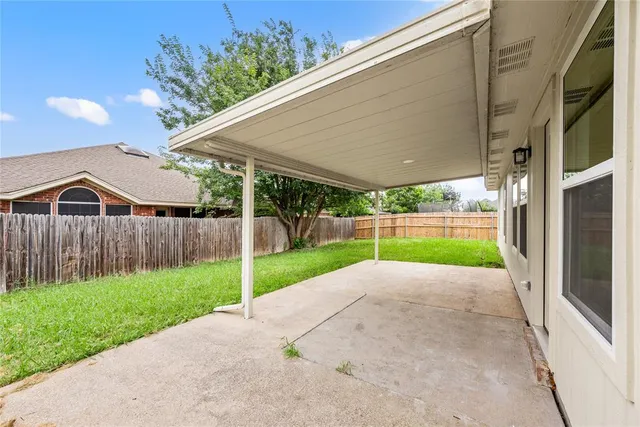 a view of a backyard with table and chairs under an umbrella