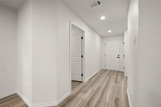 a view of a hallway with wooden floor