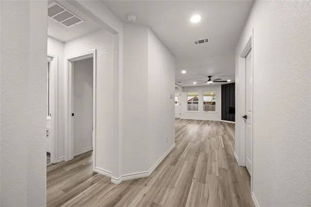 a view of a hallway with wooden floor and a fireplace