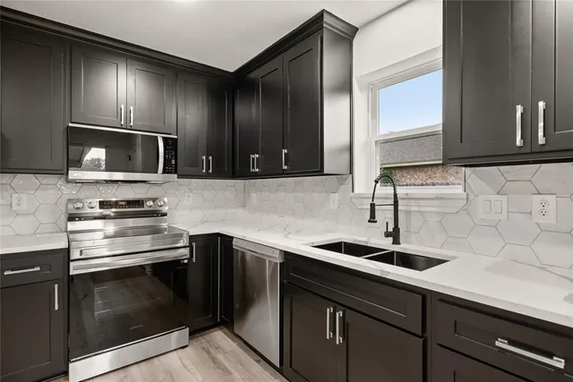 a kitchen with sink cabinets and stainless steel appliances