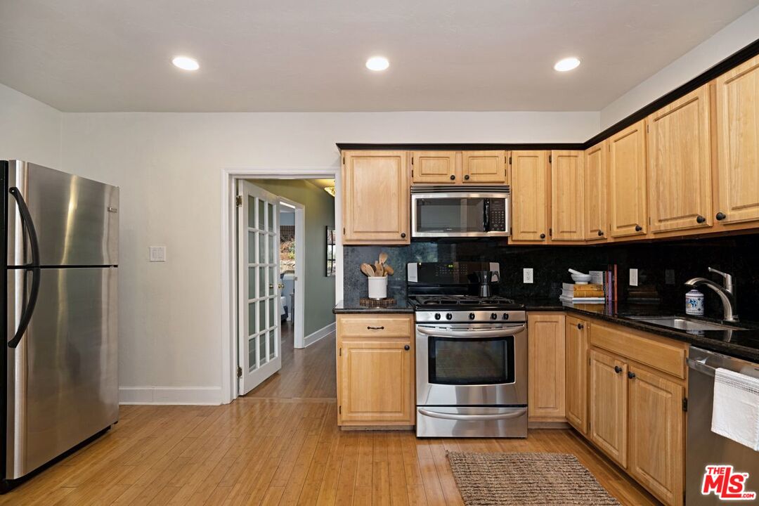 4905 Wiota Street Los Angeles, CA 90041 - Photo 13 of 38 a kitchen with stainless steel appliances granite countertop a stove a refrigerator and a microwave