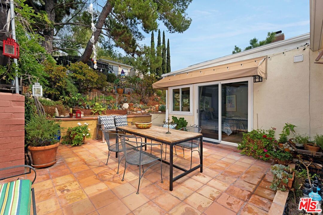 4905 Wiota Street Los Angeles, CA 90041 - Photo 26 of 38 a view of a patio with table and chairs potted plants and floor to ceiling window