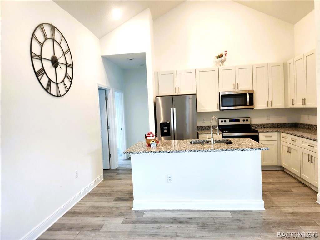 2800 Southwest 139th Street Ocala, FL 34473 - Photo 5 of 16 a kitchen with stainless steel appliances a stove refrigerator a microwave oven with a dining table and chairs
