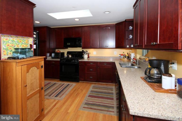 6108 Roxbury Avenue Springfield, VA 22152 - Photo 11 of 30 a kitchen with stainless steel appliances granite countertop wooden cabinets a stove top oven a sink and dishwasher