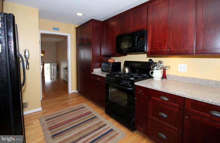 6108 Roxbury Avenue Springfield, VA 22152 - Photo 13 of 30 a kitchen with stainless steel appliances granite countertop wooden cabinets a stove top oven a sink and dishwasher