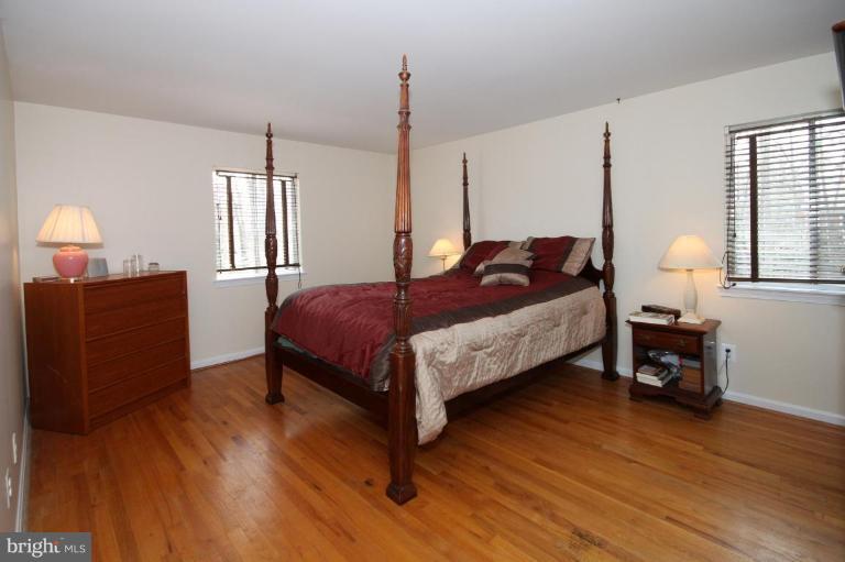 6108 Roxbury Avenue Springfield, VA 22152 - Photo 15 of 30 a spacious bedroom with a bed a dresser and wooden floor