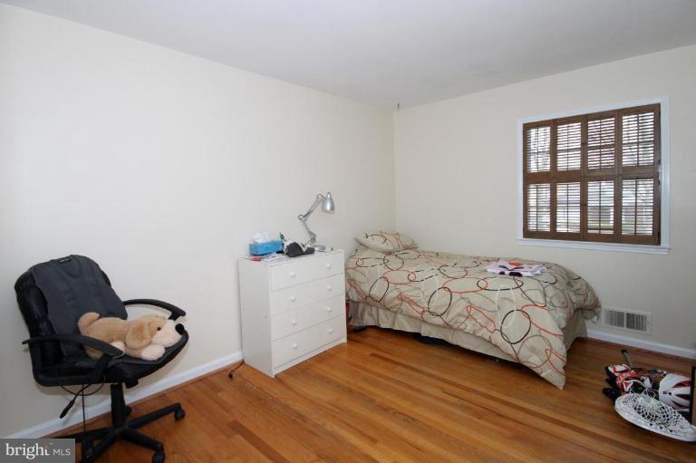 6108 Roxbury Avenue Springfield, VA 22152 - Photo 16 of 30 a bedroom with a bed and a chair