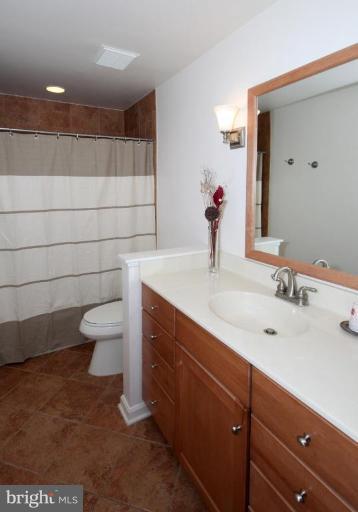6108 Roxbury Avenue Springfield, VA 22152 - Photo 21 of 30 a bathroom with a sink a toilet and mirror