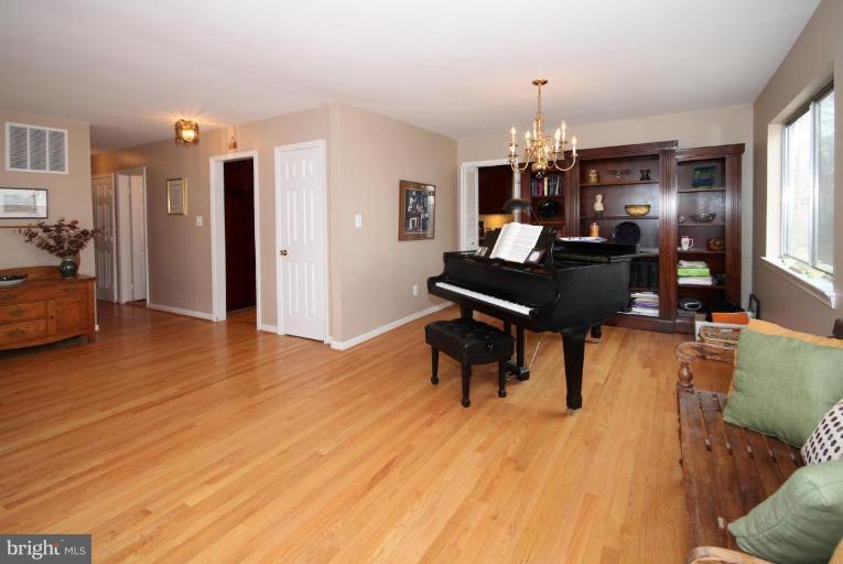 6108 Roxbury Avenue Springfield, VA 22152 - Photo 7 of 30 a living room with furniture dining table and a wooden floor