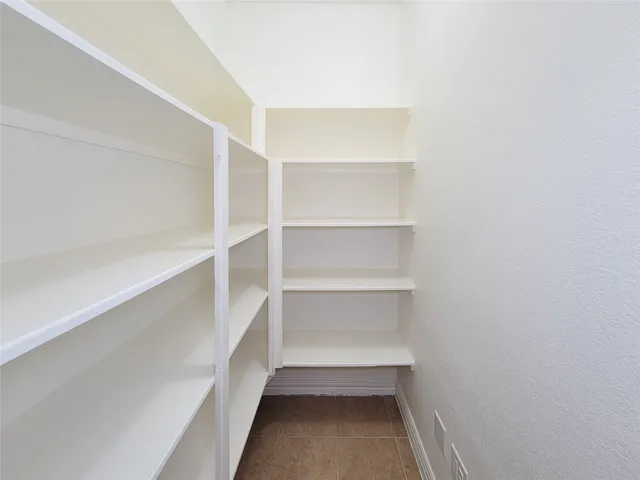 a view of a hallway with wooden floor and a cabinet