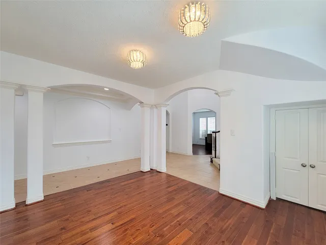a view of empty room with wooden floor and windows