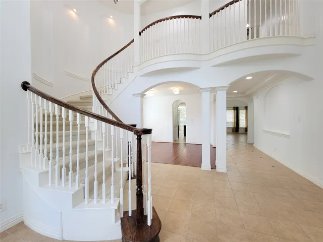 a view of staircase with white walls and a rug