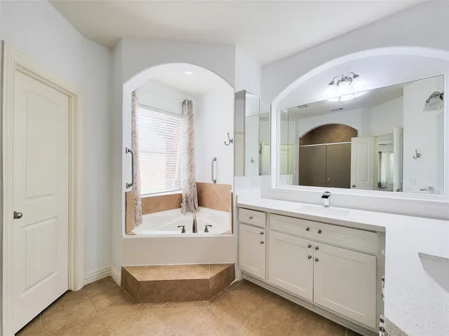 a bathroom with a bathtub sink and mirror