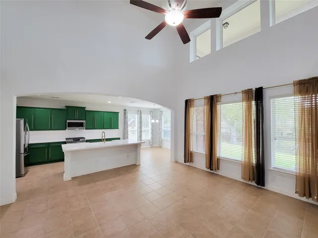 a living room with stainless steel appliances kitchen island furniture and a fireplace