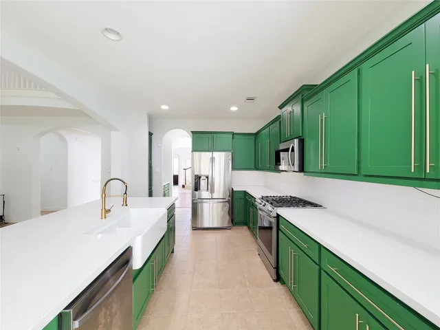 a kitchen with stainless steel appliances kitchen island a refrigerator and a sink
