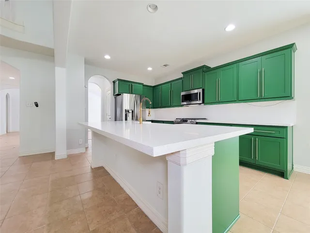 a kitchen with stainless steel appliances a sink stove and cabinets