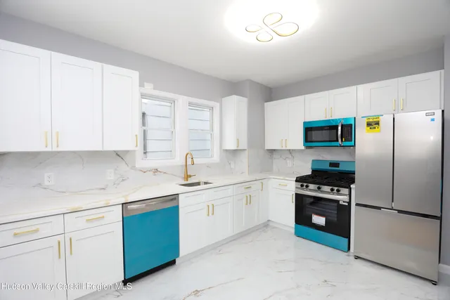 a kitchen with a sink a refrigerator and cabinets