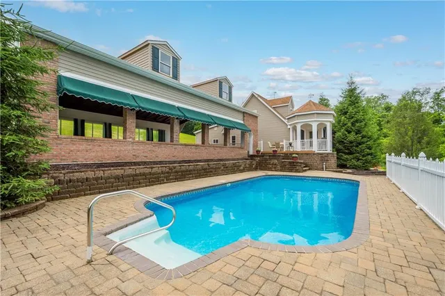 a view of a house with pool and chairs