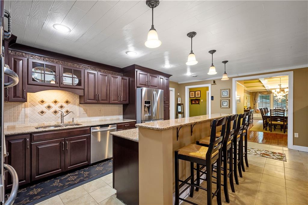 102 Klages Road West Alexander, PA 15376 - Photo 10 of 50 a kitchen with stainless steel appliances granite countertop a stove a sink a microwave oven with a dining table and chairs