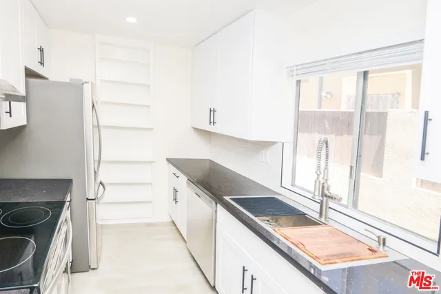a kitchen with a stove a refrigerator and a sink
