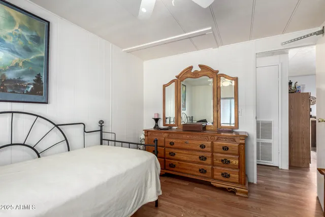 a bedroom with a bed a dresser and mirror