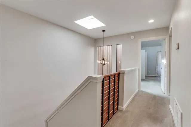 an empty room with windows and chandelier fan