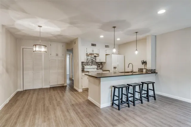 a large kitchen with a wooden floor and cabinets