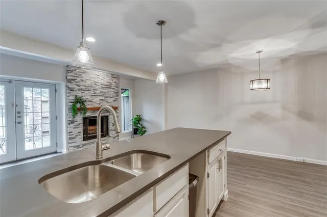 a kitchen with a sink a counter space and wooden floor