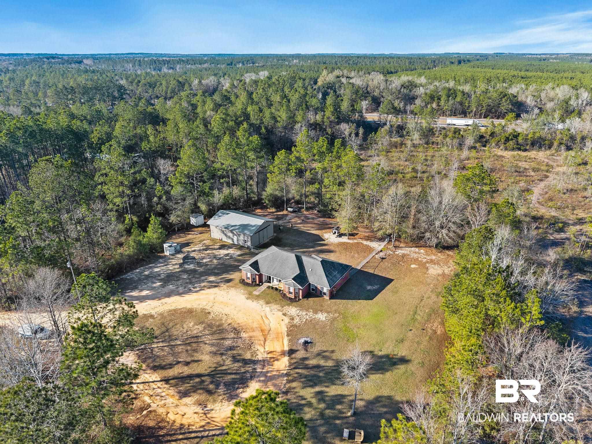 55750 Lottie Road Perdido, AL 36562 - Photo 22 of 84 Aerial view of property and surrounding area featuring a heavily wooded area