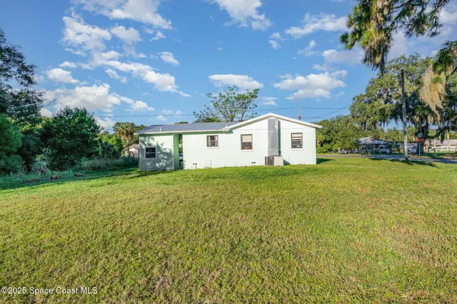 a view of a house with backyard and garden