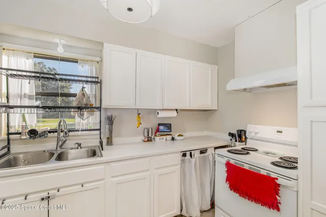 a kitchen with a sink stove and cabinets