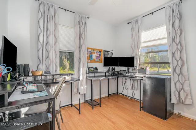 a view of a workspace with furniture and a window