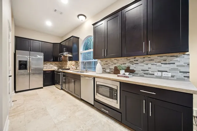 a kitchen with stainless steel appliances a sink stove and cabinets