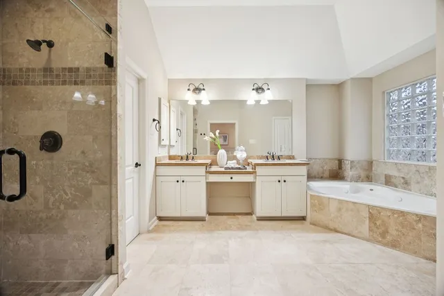 a large bathroom with a double vanity sink a mirror and a bathtub