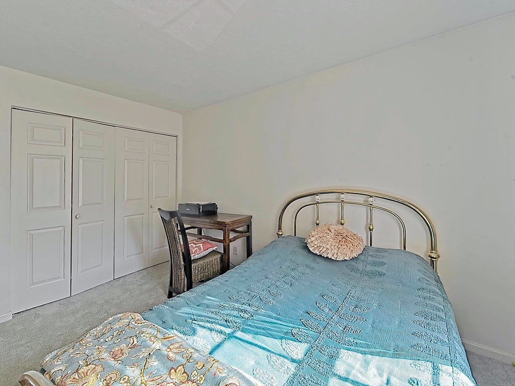 700 Shore Drive, Unit 1205 Fall River, MA 02721 - Photo 18 of 20 a bedroom with a bed and a table in it