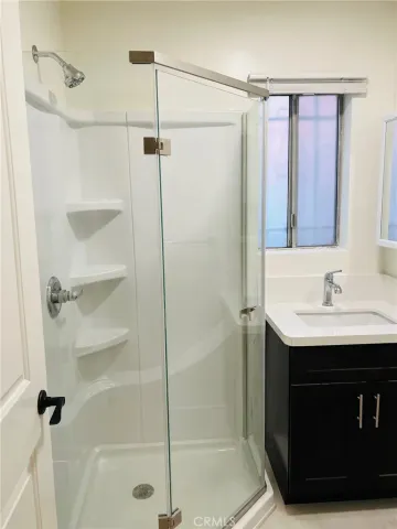 a bathroom with a sink shower and a mirror